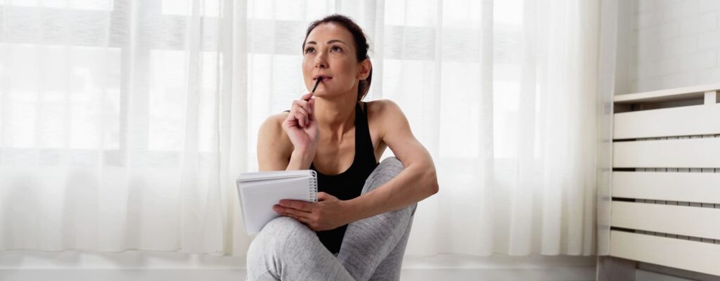 Young woman writing in her notebook about end-of-life wishes