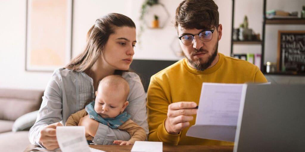 Young parents with baby looking over documents as they update their will